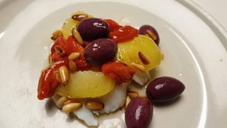 Bacallà confitat en amanida amb llesques de patata, olives de kalamata i vinagreta de pinyons
